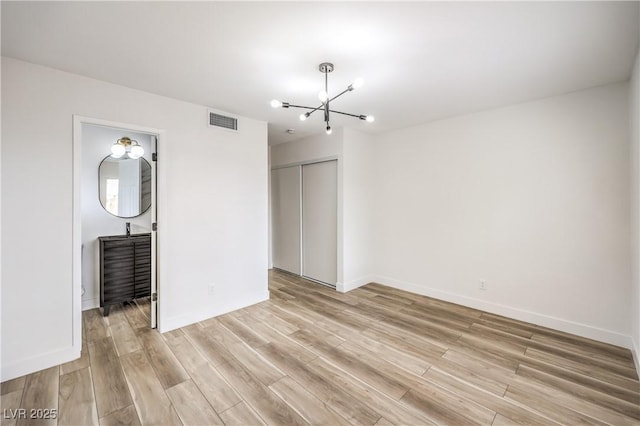 516 Donner St, Las Vegas, NV 89107 - empty room featuring a chandelier and light wood finished floors