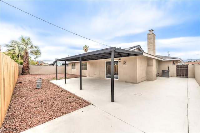 516 Donner St, Las Vegas, NV 89107 - back of house featuring stucco siding, a fenced backyard, a patio, and a chimney