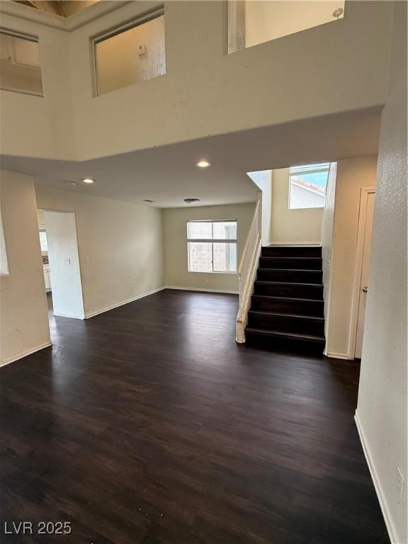 216 Night Fall Ter, Henderson, NV 89015 - unfurnished living room featuring stairway, dark wood-style flooring, a high ceiling, and recessed lighting