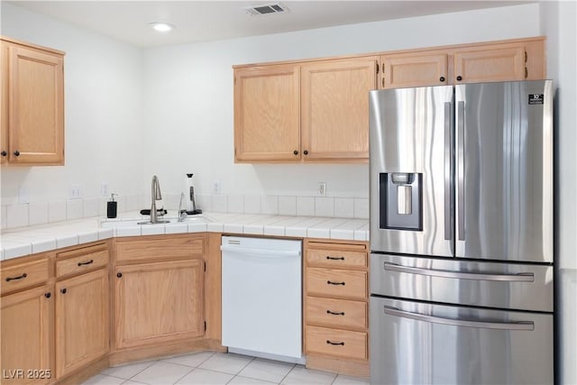 2219 Rugged Mesa Dr, Laughlin, NV 89029 - kitchen featuring stainless steel fridge with ice dispenser, dishwasher, light brown cabinets, light tile patterned floors, and recessed lighting