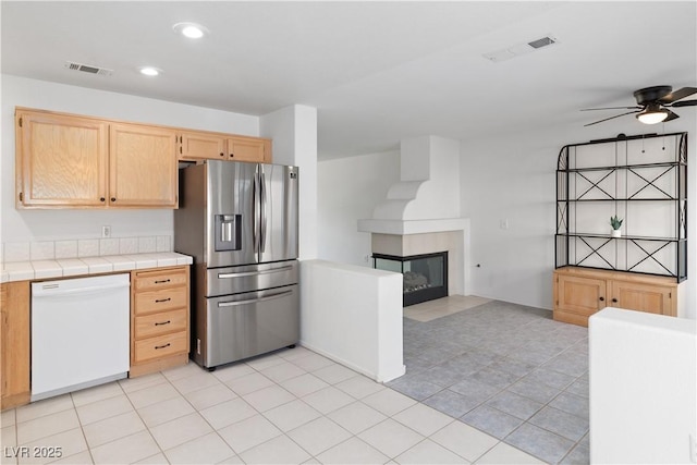 2219 Rugged Mesa Dr, Laughlin, NV 89029 - kitchen featuring dishwasher, stainless steel fridge, tile counters, light brown cabinetry, and ceiling fan