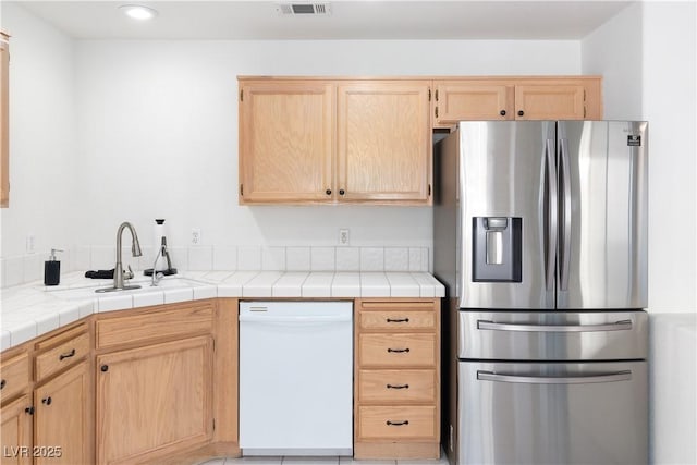 2219 Rugged Mesa Dr, Laughlin, NV 89029 - kitchen with stainless steel refrigerator with ice dispenser, white dishwasher, light brown cabinets, recessed lighting, and tile countertops