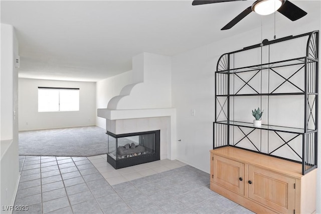 2219 Rugged Mesa Dr, Laughlin, NV 89029 - unfurnished living room featuring light tile patterned floors, ceiling fan, light carpet, and a tile fireplace