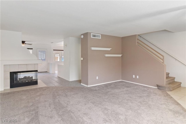 2219 Rugged Mesa Dr, Laughlin, NV 89029 - unfurnished living room featuring ceiling fan, stairs, carpet floors, tile patterned floors, and a fireplace