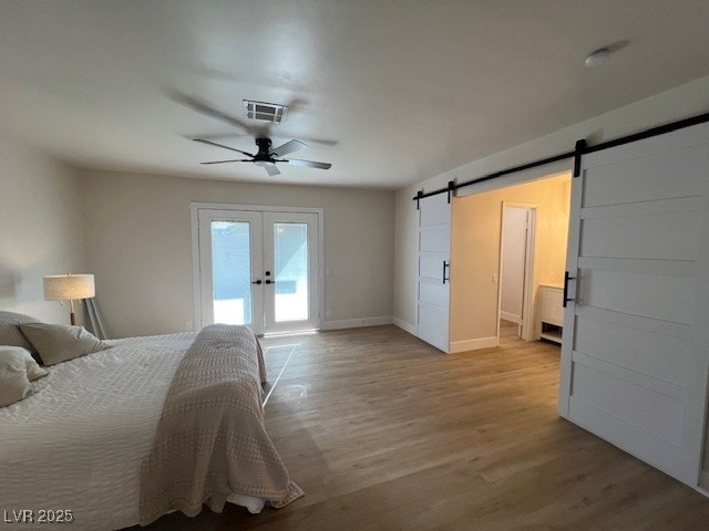 2712 Rialto Rd, Las Vegas, NV 89108 - bedroom with french doors, access to outside, a barn door, and light wood-type flooring