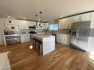 2712 Rialto Rd, Las Vegas, NV 89108 - kitchen featuring appliances with stainless steel finishes, wood finished floors, white cabinetry, light countertops, and recessed lighting