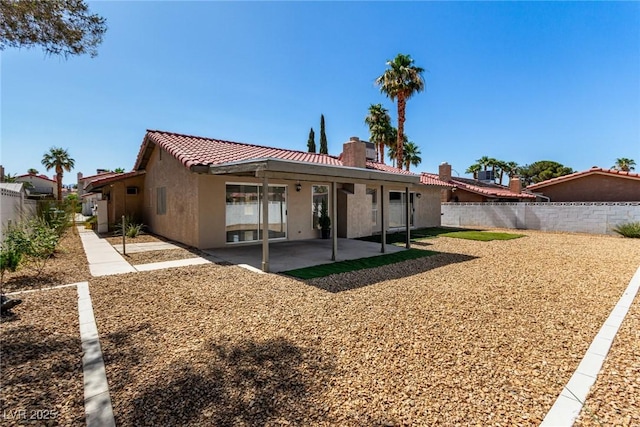 3826 Edmund St, Las Vegas, NV 89103 - rear view of property with a chimney, stucco siding, a fenced backyard, a tiled roof, and a patio area