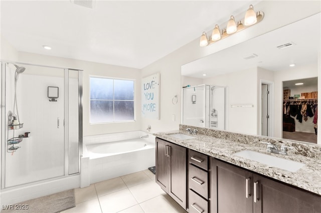 10940 Oregano Ave, Las Vegas, NV 89166 - full bath with a shower stall, a garden tub, double vanity, tile patterned floors, and a walk in closet