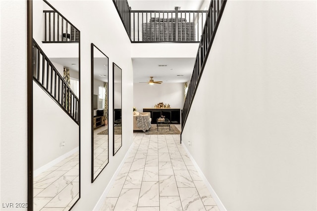 10940 Oregano Ave, Las Vegas, NV 89166 - hallway featuring light marble finish floors, stairs, and a high ceiling