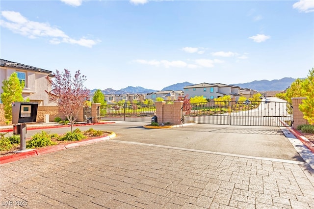 10940 Oregano Ave, Las Vegas, NV 89166 - view of road featuring a gate, a residential view, a gated entry, curbs, and a mountain view