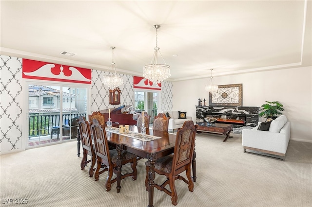 6595 Creekside Cellars Ct, Las Vegas, NV 89139 - carpeted dining room featuring a chandelier, healthy amount of natural light, ornamental molding, and a glass covered fireplace