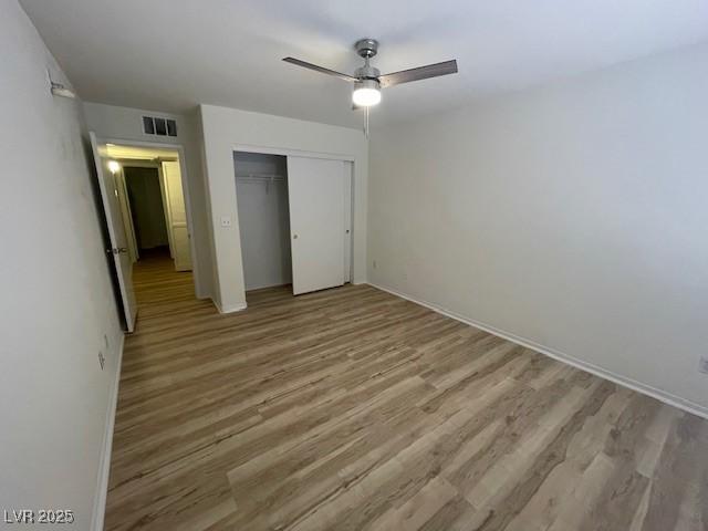 5130 Mandalay Springs Dr Unit 103, Las Vegas, NV 89120 - unfurnished bedroom with wood finished floors, a closet, and ceiling fan