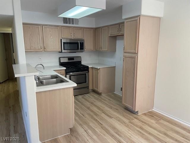 5130 Mandalay Springs Dr Unit 103, Las Vegas, NV 89120 - kitchen with appliances with stainless steel finishes, a peninsula, light wood-style floors, light countertops, and light brown cabinetry