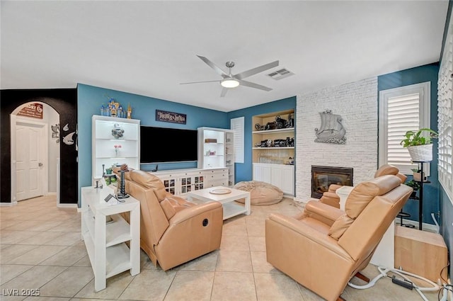 11417 Rock Cove Way, Las Vegas, NV 89141 - living room featuring light tile patterned flooring, a ceiling fan, a fireplace, and built in shelves
