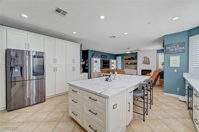 11417 Rock Cove Way, Las Vegas, NV 89141 - kitchen with stainless steel refrigerator with ice dispenser, light tile patterned flooring, a kitchen island, ceiling fan, and recessed lighting