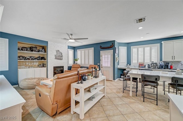 11417 Rock Cove Way, Las Vegas, NV 89141 - living room with ceiling fan, light tile patterned flooring, built in features, a large fireplace, and recessed lighting
