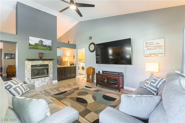 5600 Segolilly Cir, Las Vegas, NV 89130 - living area featuring ceiling fan, washing machine and clothes dryer, a glass covered fireplace, and high vaulted ceiling