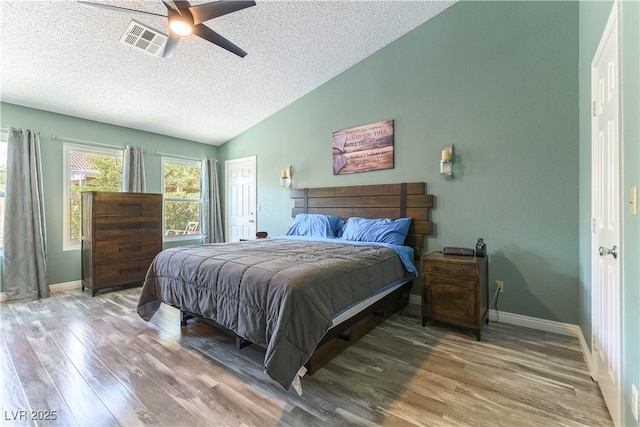 5600 Segolilly Cir, Las Vegas, NV 89130 - bedroom with wood finished floors, vaulted ceiling, a textured ceiling, and a ceiling fan