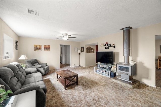 3951 W Blosser Ranch Rd, Pahrump, NV 89060 - living area with ceiling fan, a wood stove, carpet floors, and a textured ceiling