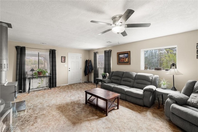 3951 W Blosser Ranch Rd, Pahrump, NV 89060 - carpeted living room with a wood stove, a ceiling fan, and a textured ceiling