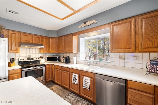 3951 W Blosser Ranch Rd, Pahrump, NV 89060 - kitchen with stainless steel appliances, under cabinet range hood, light countertops, and tasteful backsplash