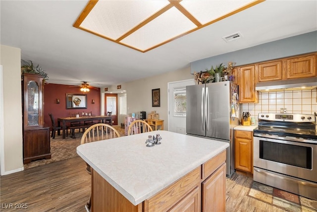 3951 W Blosser Ranch Rd, Pahrump, NV 89060 - kitchen with stainless steel appliances, under cabinet range hood, light wood finished floors, light countertops, and tasteful backsplash