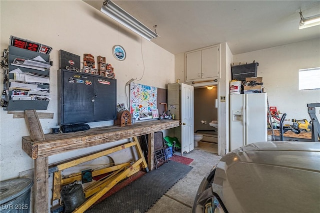 3951 W Blosser Ranch Rd, Pahrump, NV 89060 - garage with white fridge with ice dispenser and a workshop area