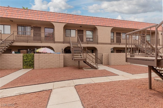 4300 N Lamont St Unit 209, Las Vegas, NV 89115 - view of front of house featuring stairway, stucco siding, and a tiled roof