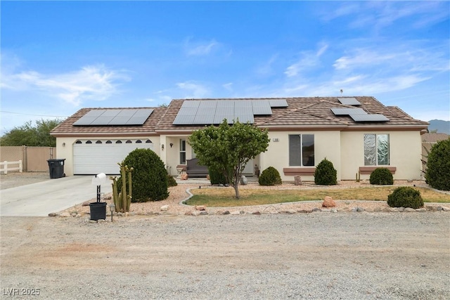 180 W Wilson Rd, Pahrump, NV 89048 - view of front of house featuring driveway, an attached garage, stucco siding, and roof mounted solar panels