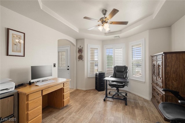 180 W Wilson Rd, Pahrump, NV 89048 - home office with a tray ceiling, arched walkways, light wood-style flooring, and a ceiling fan