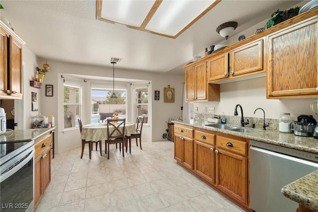 180 W Wilson Rd, Pahrump, NV 89048 - kitchen featuring stainless steel appliances, light stone countertops, and brown cabinetry