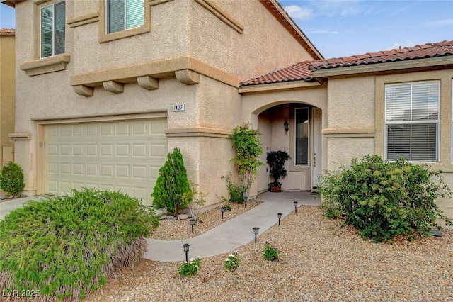 7427 Wagonwheel Ranch Way, Las Vegas, NV 89113 - doorway to property featuring a garage, stucco siding, and a tiled roof