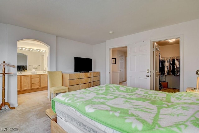 7427 Wagonwheel Ranch Way, Las Vegas, NV 89113 - bedroom featuring arched walkways, light colored carpet, a walk in closet, ensuite bath, and a closet