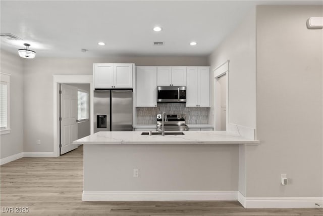 2120 Upland Ave, Pahrump, NV 89048 - kitchen featuring appliances with stainless steel finishes, tasteful backsplash, light stone counters, white cabinets, and recessed lighting