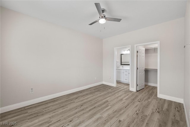 2120 Upland Ave, Pahrump, NV 89048 - unfurnished bedroom with light wood-style floors, a closet, a walk in closet, ensuite bath, and a ceiling fan