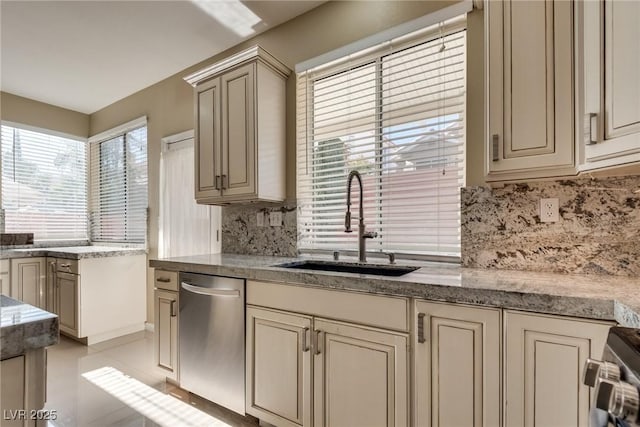 2245 Juniper Berry Dr, Las Vegas, NV 89134 - kitchen with stainless steel dishwasher, tasteful backsplash, cream cabinetry, and range
