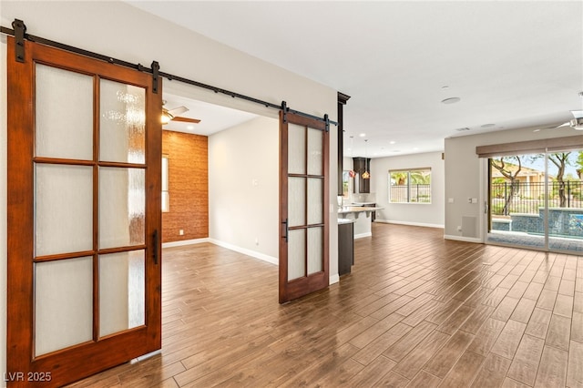 2116 Canvas Edge Dr, Henderson, NV 89044 - unfurnished living room featuring a barn door, wood finished floors, and recessed lighting