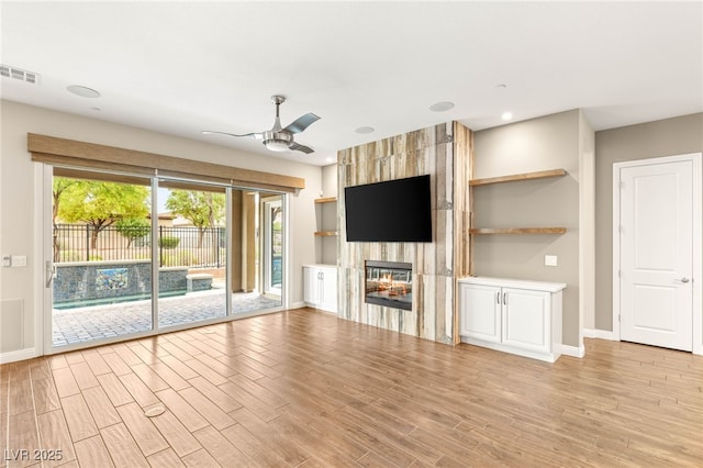 2116 Canvas Edge Dr, Henderson, NV 89044 - unfurnished living room with a ceiling fan, a large fireplace, light wood-style flooring, and recessed lighting