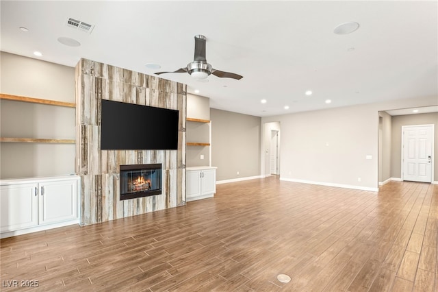 2116 Canvas Edge Dr, Henderson, NV 89044 - unfurnished living room featuring light wood finished floors, a large fireplace, a ceiling fan, and recessed lighting