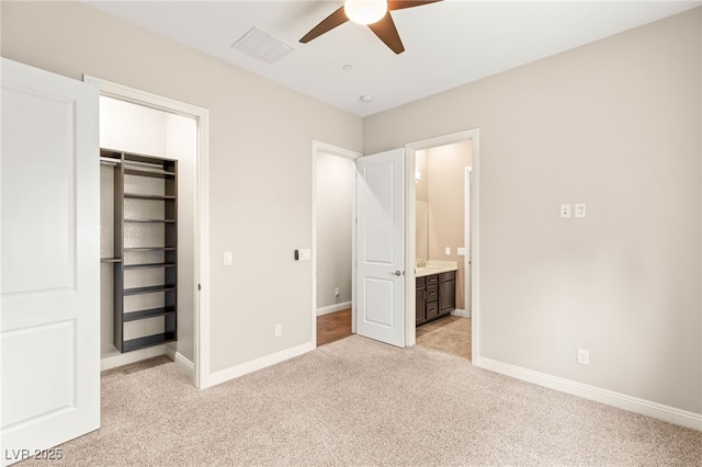 2116 Canvas Edge Dr, Henderson, NV 89044 - unfurnished bedroom with light carpet, ensuite bath, a closet, ceiling fan, and a walk in closet