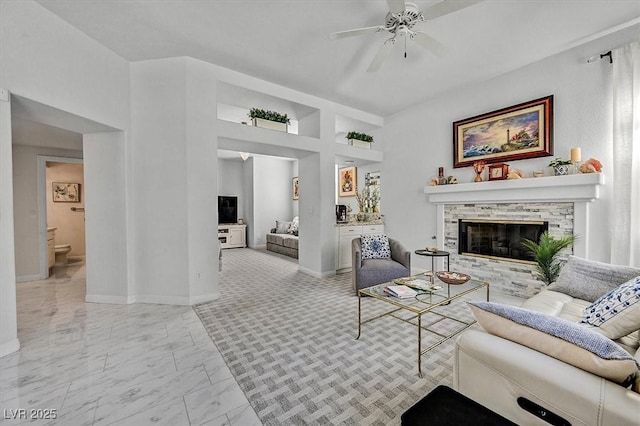 2021 Waterbury Ln, Las Vegas, NV 89134 - living area featuring a ceiling fan, a fireplace, and light marble finish floors