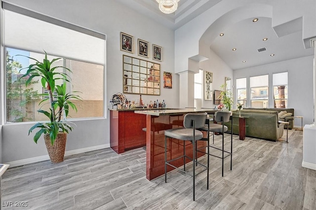 2021 Waterbury Ln, Las Vegas, NV 89134 - indoor bar featuring light wood-type flooring, recessed lighting, arched walkways, and high vaulted ceiling