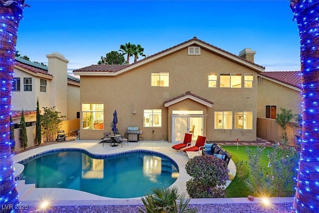 2021 Waterbury Ln, Las Vegas, NV 89134 - back of property with stucco siding, a putting green, a patio, and an outdoor pool