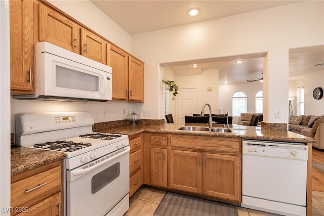 3412 Bearpin Gap Ln, Las Vegas, NV 89129 - kitchen with white appliances, a peninsula, open floor plan, dark stone countertops, and recessed lighting