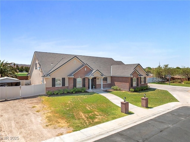 2477 Adobe Wells Dr, Logandale, NV 89021 - view of front facade with a tile roof, brick siding, driveway, and stucco siding