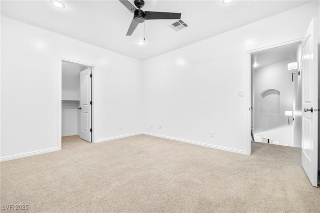 2477 Adobe Wells Dr, Logandale, NV 89021 - unfurnished bedroom with light carpet, a walk in closet, ceiling fan, recessed lighting, and a closet