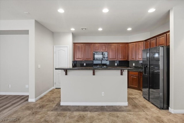 924 Crescent Falls St, Henderson, NV 89011 - kitchen with refrigerator with ice dispenser, black microwave, a kitchen breakfast bar, decorative backsplash, and recessed lighting