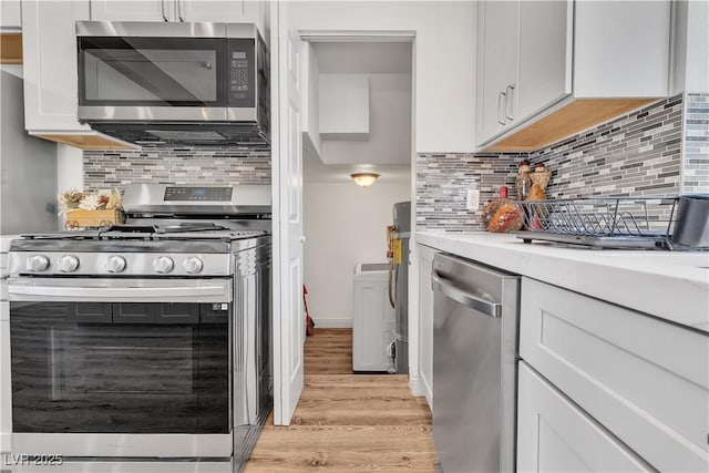 4654 Gabriel Dr, Las Vegas, NV 89121 - kitchen with stainless steel appliances, light wood finished floors, light countertops, decorative backsplash, and white cabinets
