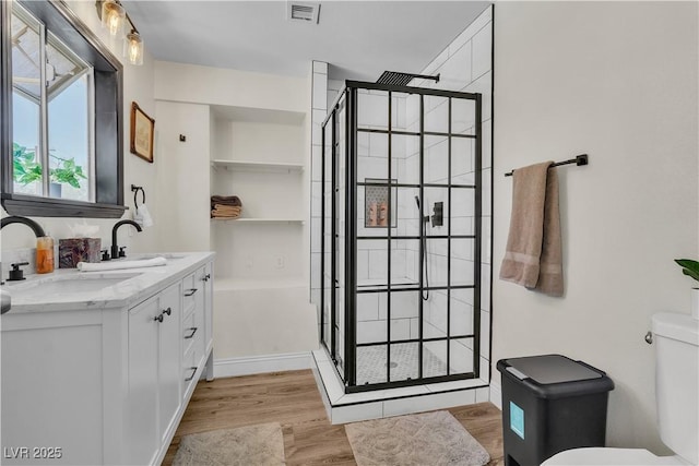 4654 Gabriel Dr, Las Vegas, NV 89121 - bathroom featuring wood finished floors, a stall shower, and double vanity