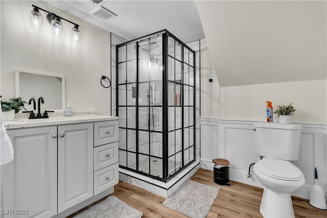4654 Gabriel Dr, Las Vegas, NV 89121 - bathroom with vanity, a shower stall, wood finished floors, and wainscoting